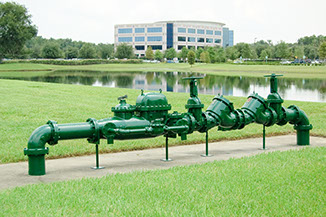 Backflow regulator with office building in the background.